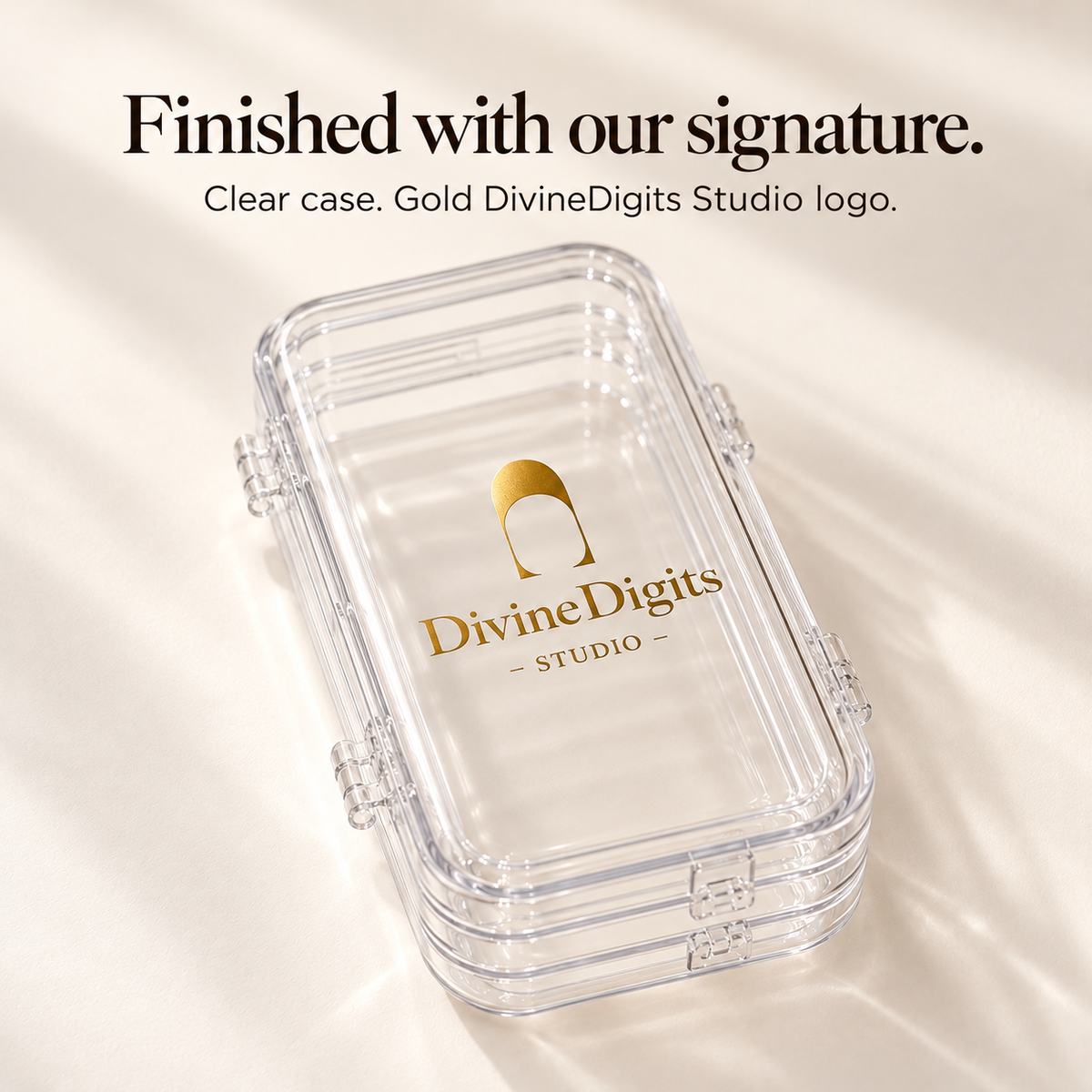 Close view of the gold DivineDigits Studio logo on a clear folded nail storage case.